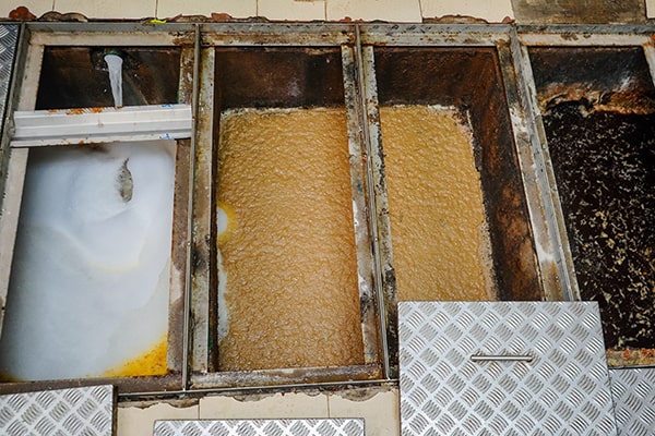 grease trap maintenance involves emptying, cleaning, and inspecting the trap to remove accumulated grease and solids
